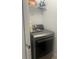 Laundry room features modern gray dryer and storage shelves at 2011 E Esther St, Orlando, FL 32806