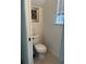 Compact powder room featuring a toilet, small window, and neutral decor at 2011 E Esther St, Orlando, FL 32806