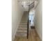 Carpeted staircase with dark wood railing, leading to a bright and open living space at 2011 E Esther St, Orlando, FL 32806