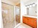 Bathroom featuring a tile shower with a glass door, vanity with sink, and neutral tile floors at 2404 Bella Vista Dr, Davenport, FL 33897