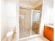 Bathroom featuring a tile shower with glass door, toilet, vanity with sink, and neutral tile floors at 2404 Bella Vista Dr, Davenport, FL 33897