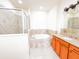 Upscale bathroom features a shower with glass door, a soaking tub, and a vanity with granite countertop at 2404 Bella Vista Dr, Davenport, FL 33897
