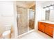 Bathroom featuring a tile shower with glass door, toilet, vanity with sink, and neutral tile floors at 2404 Bella Vista Dr, Davenport, FL 33897