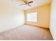 Bright bedroom with plush carpet, a ceiling fan, and a sun-filled window create a cozy retreat at 2404 Bella Vista Dr, Davenport, FL 33897