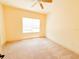 Bright carpeted bedroom featuring ceiling fan, base trim and a large window at 2404 Bella Vista Dr, Davenport, FL 33897