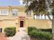 Inviting townhome exterior features a private courtyard, lush landscaping, and a warm, textured facade at 2404 Bella Vista Dr, Davenport, FL 33897