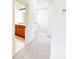Bright hallway leading to bathroom with a tile shower featuring a glass door and a wood vanity at 2404 Bella Vista Dr, Davenport, FL 33897