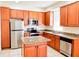The kitchen is fully equipped with stainless steel appliances, cherry wood cabinetry, and granite countertops at 2404 Bella Vista Dr, Davenport, FL 33897