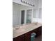Bathroom with a large mirror, double sinks, and ample cabinet space, complemented by a storage rack at 2543 Chapala Dr, Kissimmee, FL 34746