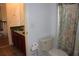 Traditional bathroom with a toilet and vanity featuring a green countertop and cherry wood cabinets at 2543 Chapala Dr, Kissimmee, FL 34746