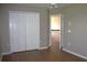 Well-lit bedroom with laminate floors, closet space, and access to the hallway at 2543 Chapala Dr, Kissimmee, FL 34746