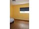 Bright bedroom featuring wood-look floors, yellow walls and a window with dark shades at 2543 Chapala Dr, Kissimmee, FL 34746