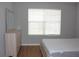 Bedroom featuring wood-look floors, dresser and a window with white blinds at 2543 Chapala Dr, Kissimmee, FL 34746