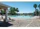 Community pool with paved deck surrounded by palm trees and greenery at 2543 Chapala Dr, Kissimmee, FL 34746