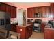Charming kitchen with dark wood cabinets, granite counters, and stainless steel appliances at 2543 Chapala Dr, Kissimmee, FL 34746