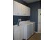 Well-equipped laundry room featuring white cabinets, washer, dryer and utility sink at 2543 Chapala Dr, Kissimmee, FL 34746