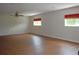 Spacious living room with wood laminate flooring, a ceiling fan, and windows covered by curtains at 2543 Chapala Dr, Kissimmee, FL 34746