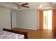 Comfortable main bedroom with wood laminate flooring, ceiling fan, and access to patio at 2543 Chapala Dr, Kissimmee, FL 34746