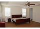 Well-lit main bedroom featuring a tray ceiling, ceiling fan, and wood laminate flooring at 2543 Chapala Dr, Kissimmee, FL 34746
