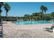 Community pool surrounded by brick pavers and palm trees, offering a relaxing oasis at 2543 Chapala Dr, Kissimmee, FL 34746