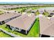Community aerial view featuring neat rows of homes, lush greenery, and a serene lake backdrop at 2578 Cliff Way, St Cloud, FL 34771