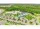 Aerial view of community center, tennis courts, pool, and lush greenery with a serene lake backdrop at 2578 Cliff Way, St Cloud, FL 34771