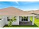 Exterior view of the home's covered patio, windows, manicured lawn, and landscape design at 2578 Cliff Way, St Cloud, FL 34771