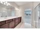 Bright bathroom featuring double sinks, spacious shower with glass door and tile flooring at 2578 Cliff Way, St Cloud, FL 34771