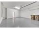 Spacious garage with gray epoxy flooring, white walls, door to house, and garage door hardware at 2578 Cliff Way, St Cloud, FL 34771