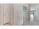 Clean hallway with ceramic tile flooring and white walls, offering a view into other rooms of the home at 2578 Cliff Way, St Cloud, FL 34771