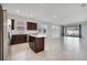 Open floor plan featuring a kitchen, island, and living room with sliding glass doors to the backyard at 2578 Cliff Way, St Cloud, FL 34771