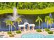 Beautiful view of a fountain in a pond, poolside seating, and mature palm trees at 2578 Cliff Way, St Cloud, FL 34771