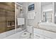 Elegant bathroom featuring a tub, wood-look tiling, glass shower door and granite counter at 2630 Sunrise Shores Dr, Kissimmee, FL 34747