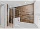 Modern bathroom featuring a shower and a soaking tub with wood-look accent wall at 2630 Sunrise Shores Dr, Kissimmee, FL 34747
