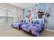 Themed bedroom with two twin beds, bright wallpaper, and playful décor at 2630 Sunrise Shores Dr, Kissimmee, FL 34747