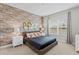Comfortable bedroom featuring a brick accent wall, neutral tones, and bright natural light at 2630 Sunrise Shores Dr, Kissimmee, FL 34747