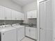 Well-equipped laundry room with washer, dryer, granite counters, and ample cabinet space at 2630 Sunrise Shores Dr, Kissimmee, FL 34747