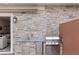 Outdoor kitchen with stone backsplash, stainless steel grill, sink, and counter space at 2630 Sunrise Shores Dr, Kissimmee, FL 34747