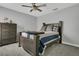 Bedroom featuring a dark wood bed frame, dresser, ceiling fan and gray carpeting at 2657 Bullion Loop, Sanford, FL 32771