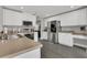 Bright kitchen features white cabinets, stainless steel appliances, and sleek gray flooring at 2657 Bullion Loop, Sanford, FL 32771