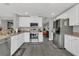 Bright kitchen features white cabinets, stainless steel appliances, and sleek gray flooring at 2657 Bullion Loop, Sanford, FL 32771