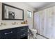 Bathroom featuring a blue vanity, a large mirror, and a shower with a decorative shower curtain at 2809 Redditt Rd, Orlando, FL 32822
