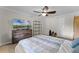 This bedroom features light wood-look flooring, a ceiling fan, and a dresser topped with a flat-screen TV at 2809 Redditt Rd, Orlando, FL 32822