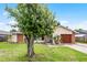 Inviting home exterior with a lush green lawn, mature tree, and a well-maintained facade at 2809 Redditt Rd, Orlando, FL 32822