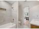 Renovated bathroom featuring white tiled walls, a shower and tub, with gold fixtures at 2829 Lake Griffin Rd, Lady Lake, FL 32159