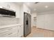 Open kitchen with stainless steel refrigerator, white cabinets and countertops, and open shelving at 2829 Lake Griffin Rd, Lady Lake, FL 32159