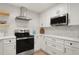 Stylish kitchen boasts white cabinets, quartz countertops, stainless steel appliances and modern backsplash at 2829 Lake Griffin Rd, Lady Lake, FL 32159