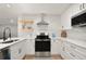 Beautiful kitchen features white cabinets, quartz countertops, stainless steel appliances and modern open shelving at 2829 Lake Griffin Rd, Lady Lake, FL 32159
