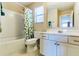 Well-lit bathroom features a white vanity, toilet, and tub/shower combination with a decorative shower curtain at 312 Partridge Pea Ln, Ocoee, FL 34761