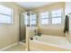 Bright bathroom featuring a bathtub, a shower, and multiple windows for a serene bathing experience at 312 Partridge Pea Ln, Ocoee, FL 34761
